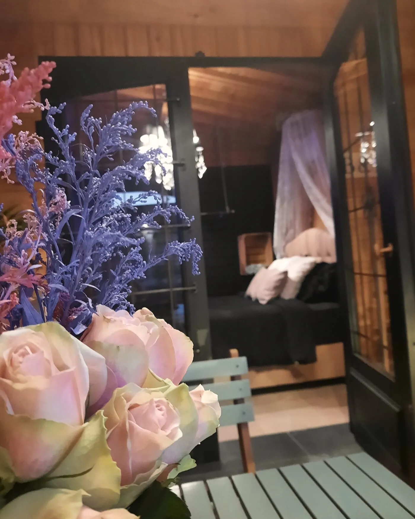 De B&B-kamer bij avond, met het hemelbed onder de houten wanden