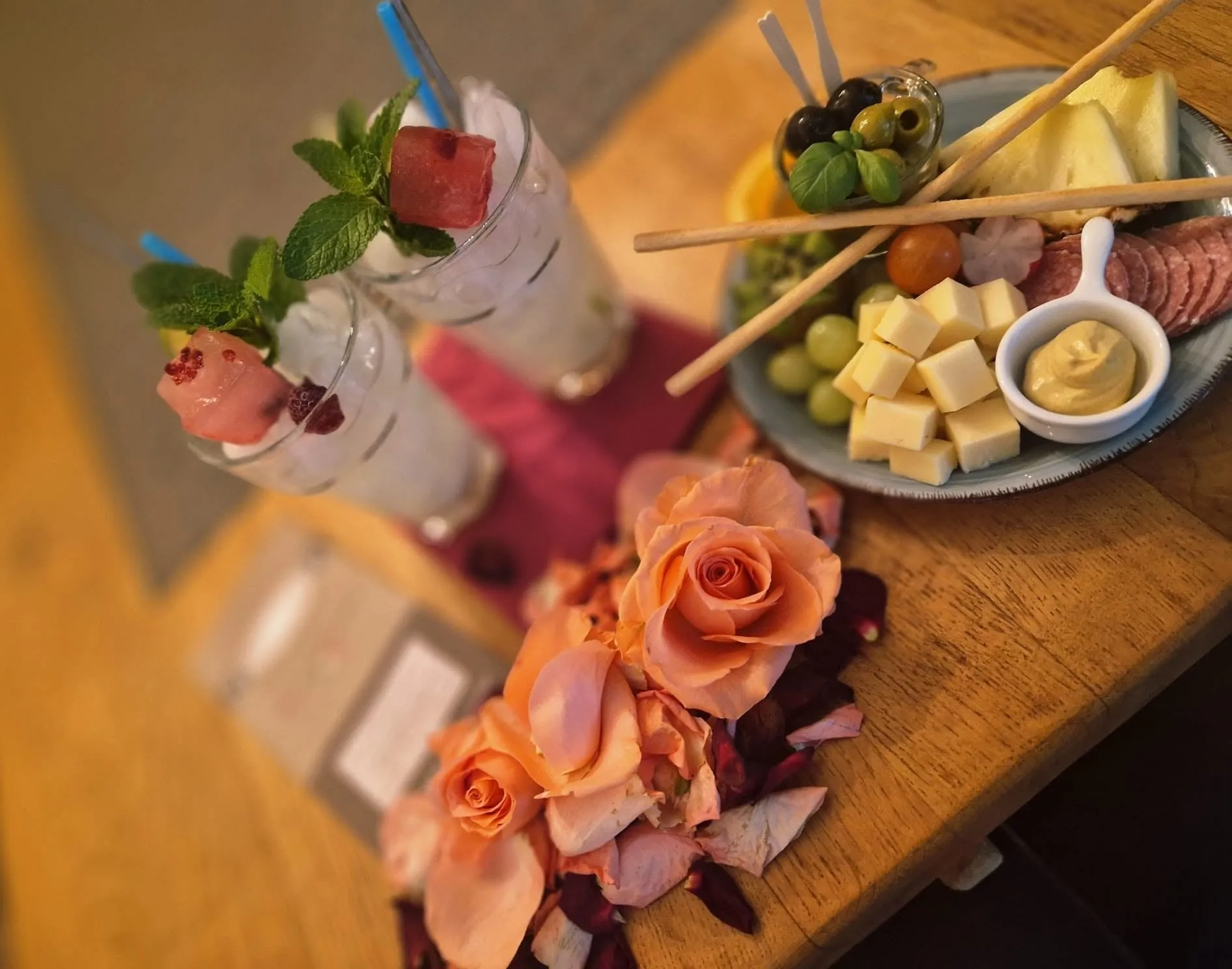 Cocktails en een tapasplank met rozen op tafel