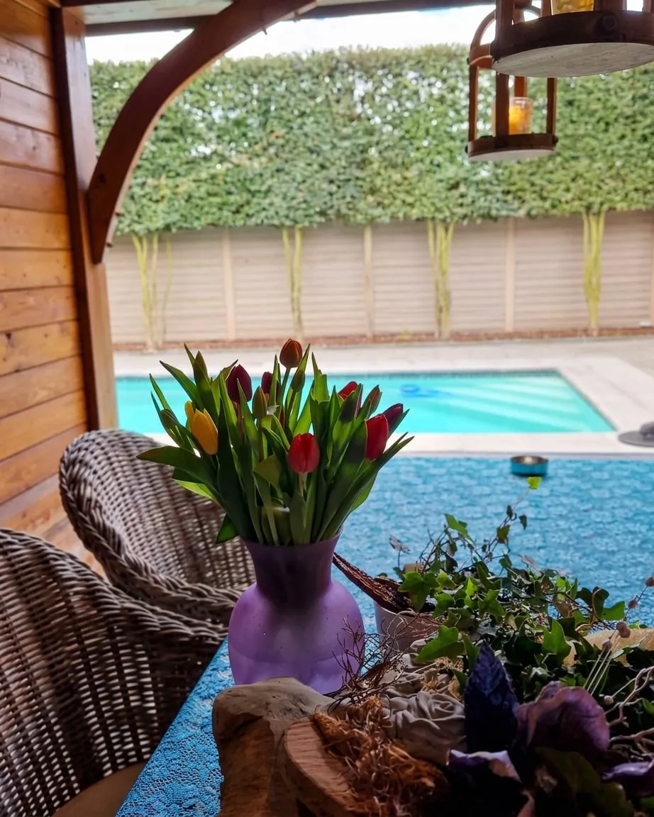 Tulpen op de tafel in het poolhouse, met het zwembad erachter