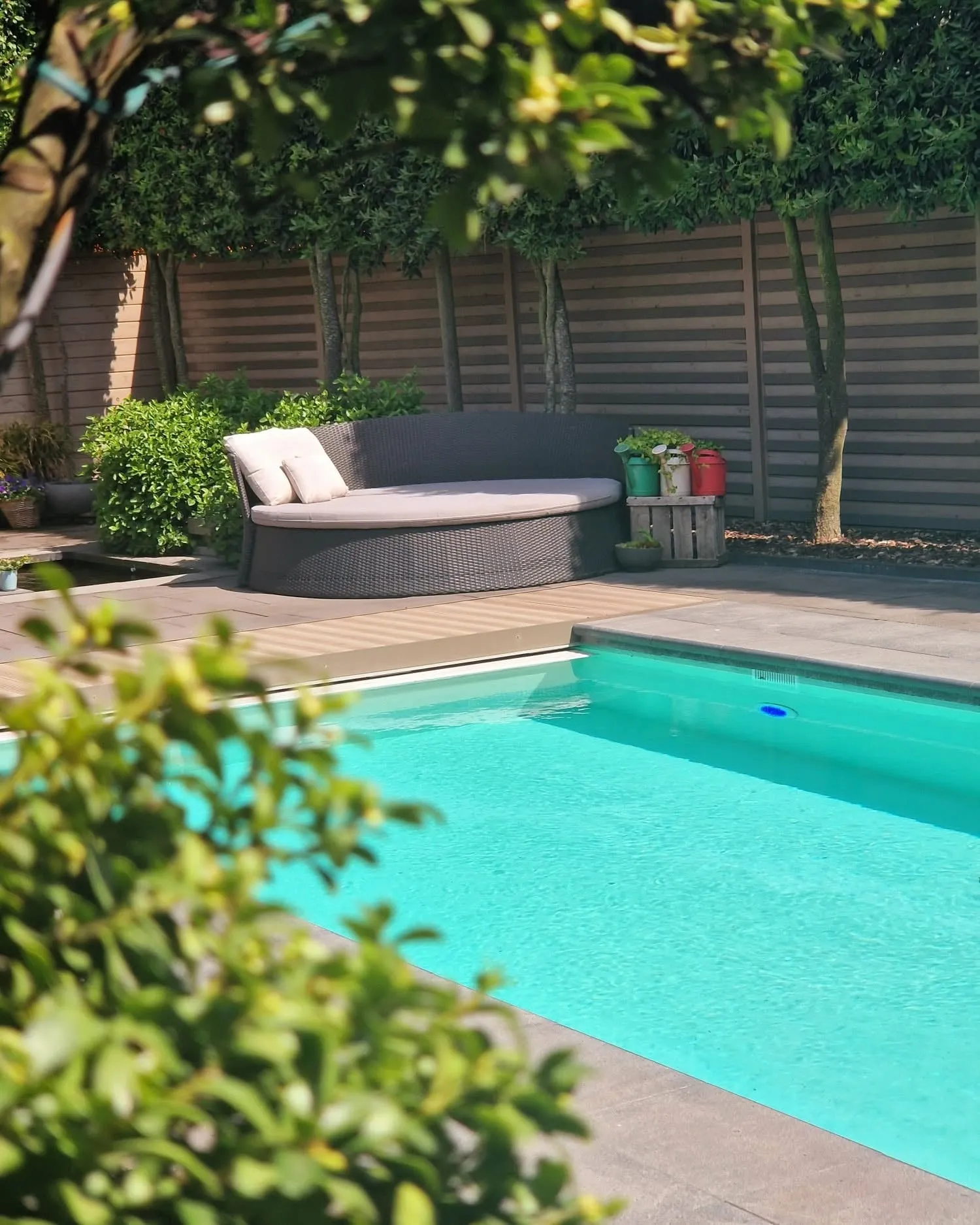 Het zwembad met de loungebank, in de zomerzon